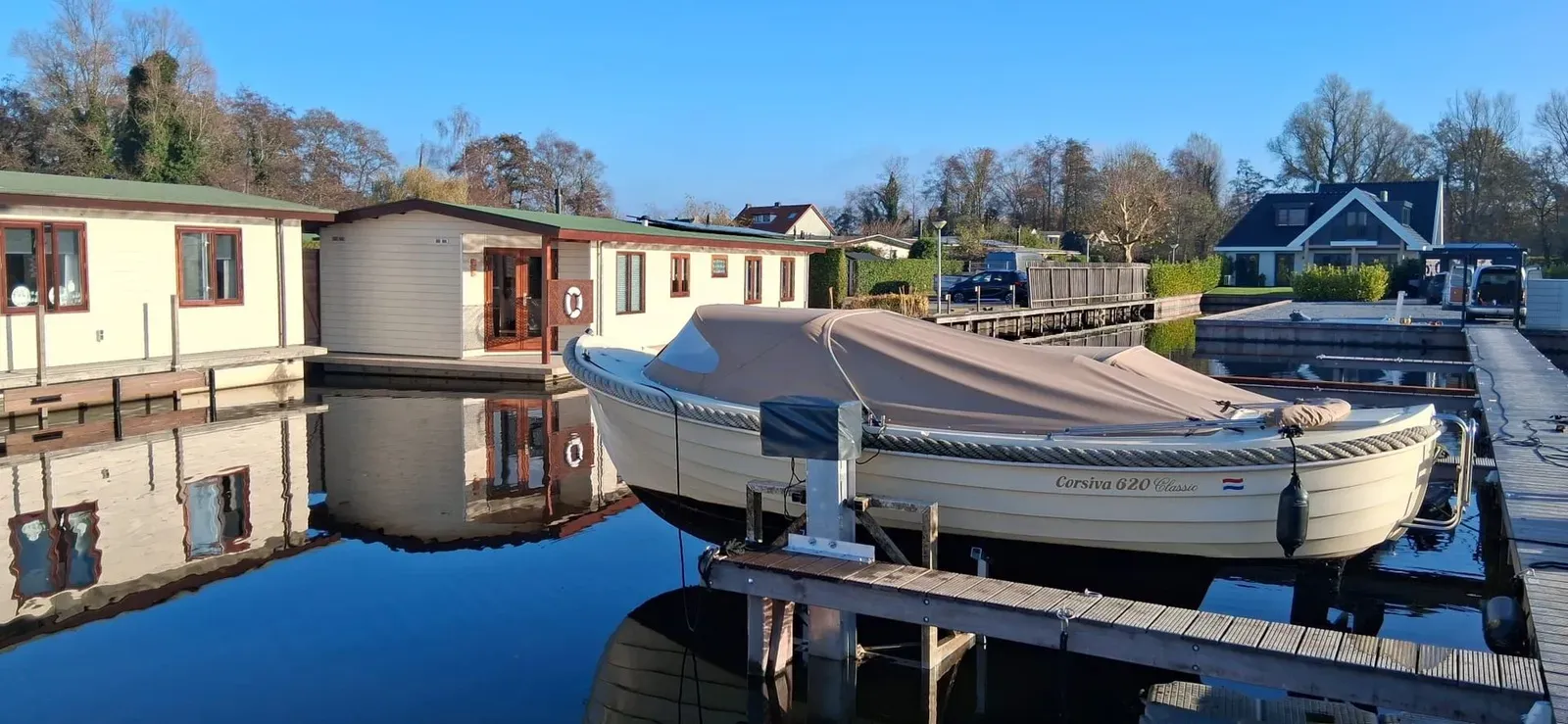 Sloep met dekzeil op een kadelift aan een steiger in Kortenhoef