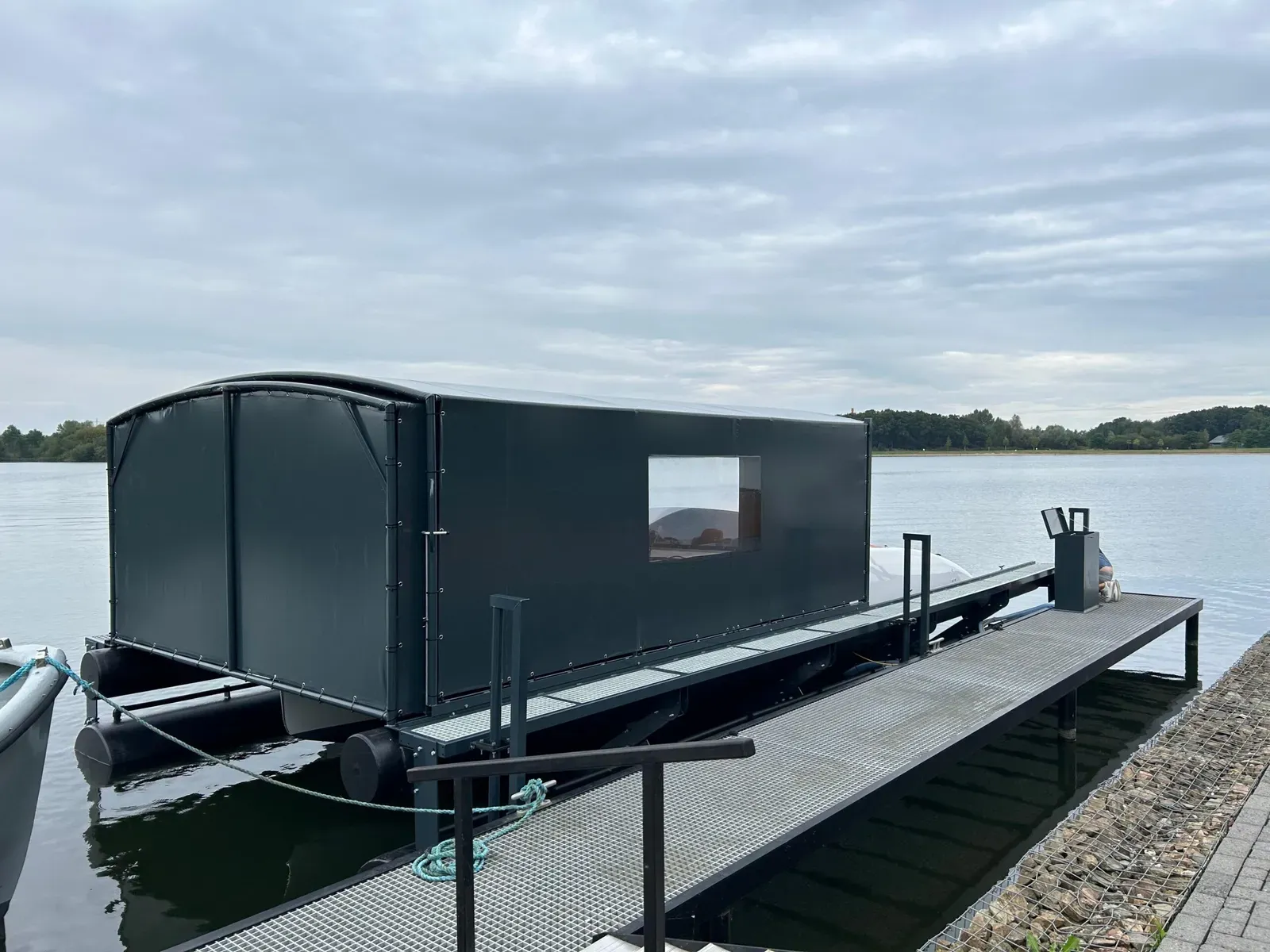 Bootoverkapping met bootlift en loopsteiger op een meer
