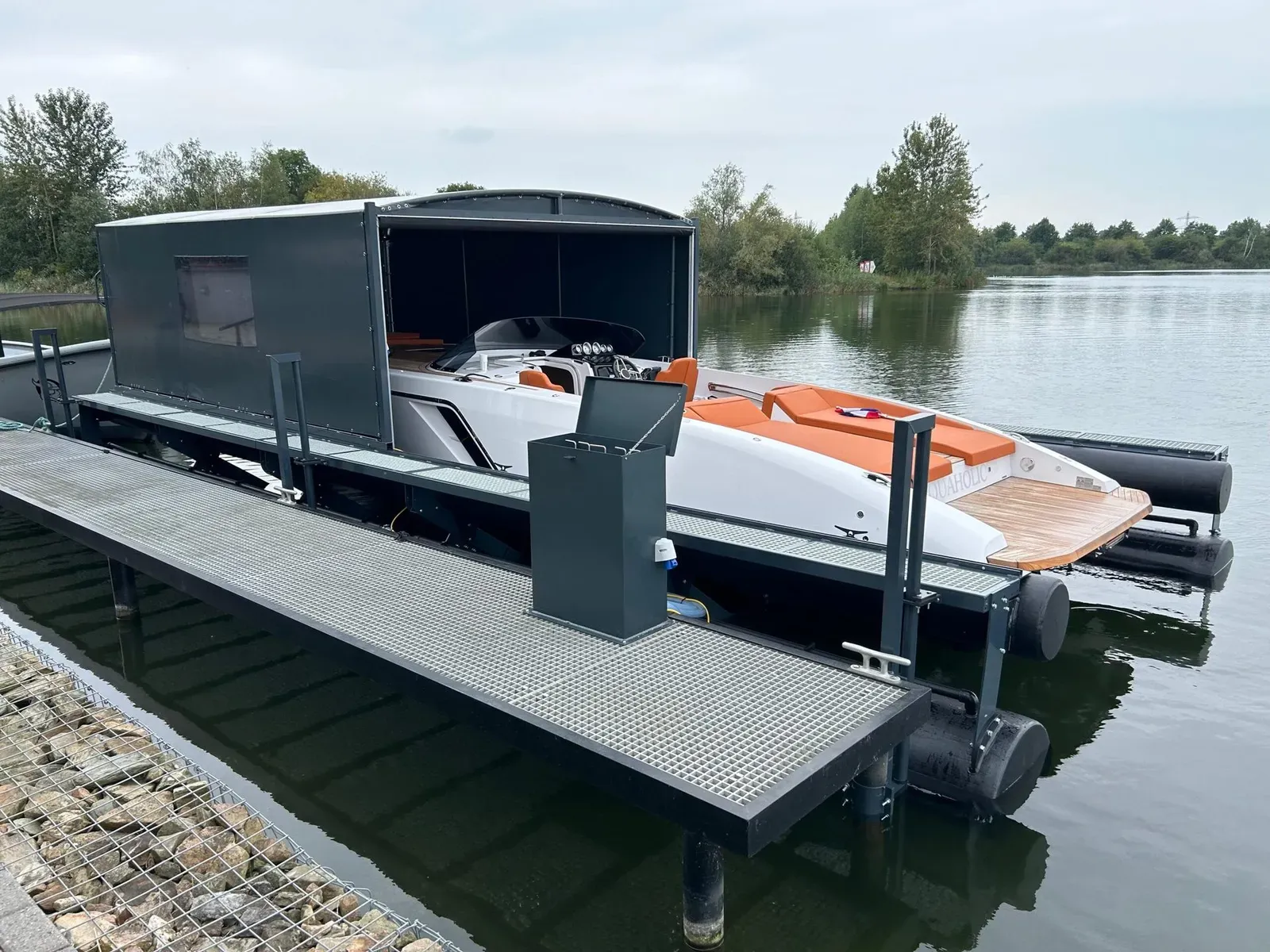Motorboot op een drijvende bootlift onder een geopende bootoverkapping